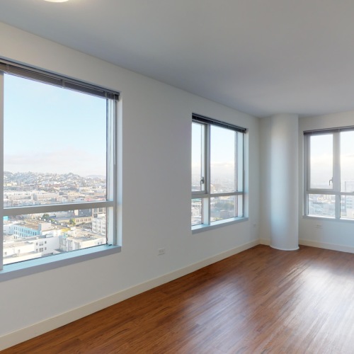 Studio Apartments In San Francisco CA - Trinity Place At 1188 - Living Room Featuring Large Windows With City Views And Wood Style Flooring Studio Apartments In San Francisco CA - Trinity Place At 1188 - Living Room Featuring Large Windows With City Views And Wood Style Flooring